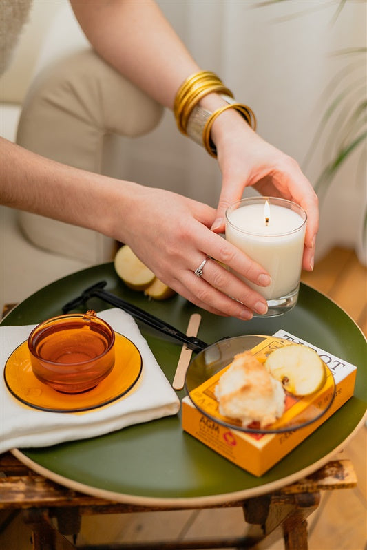 Bougie parfumée allumée dans un intérieur minimaliste pour créer une ambiance cocooning et apaisante