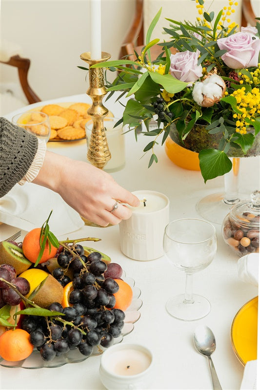 Bougie faite main présentée comme cadeau dans un intérieur chaleureux et soigné