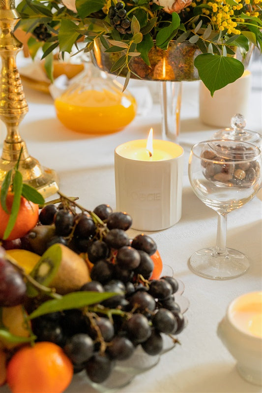 Bougie parfumée allumée dans un intérieur chaleureux avec une flamme stable.